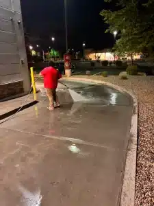 echnician pressure washing a dirty drive-thru lane at a fast food restaurant in Phoenix.